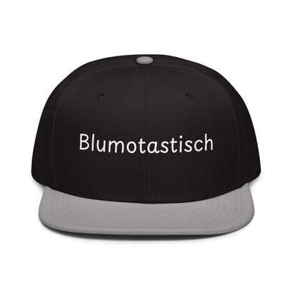 Blumotastisch Snapback Cap in Schwarz - Grau aus Acryl-Woll-Mix - neues Wort für Perfektion und Schönheit - Front - Wortstolz Design