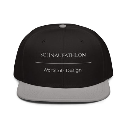 Schnaufathlon Snapback Cap in Schwarz - Grau aus Acryl-Woll-Mix - neues Wort für Anstrengung und Stolz - Front - Wortstolz Design