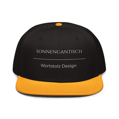 Sonnengantisch Snapback Cap in Schwarz - Gold aus Acryl-Woll-Mix - neues Wort für Strahlkraft und Energie - Front - Wortstolz Design
